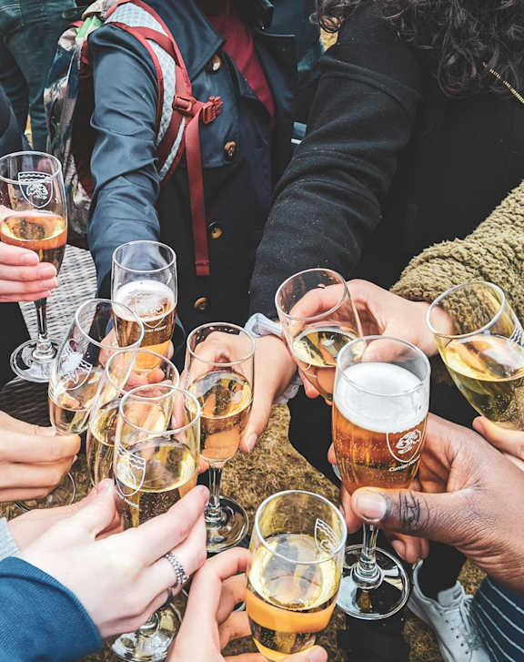 A group of people clinking glasses together in a toast.