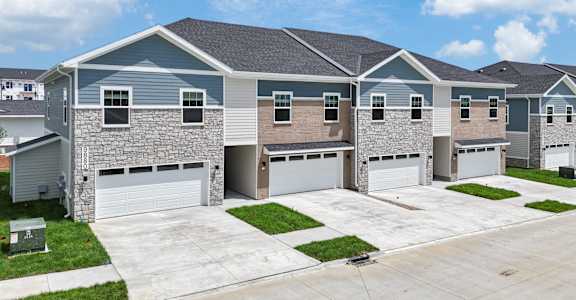 A row of houses with garages and driveways.