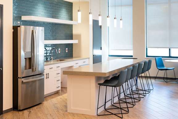 A modern kitchen with a large island and bar stools.