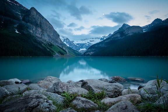 a blue lake with mountains in the background
