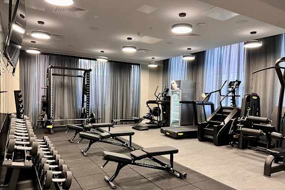 a gym with treadmills and other exercise equipment in a large room with windows