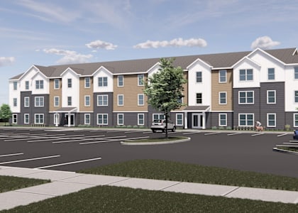 A rendering of a modern apartment complex with a parking lot in front.