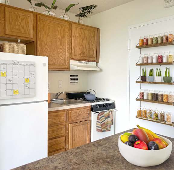 A white fridge with a calendar on it in a kitchen.