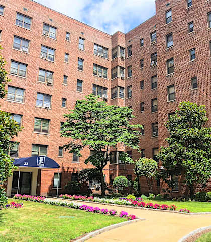 a large brick building with trees in front of it