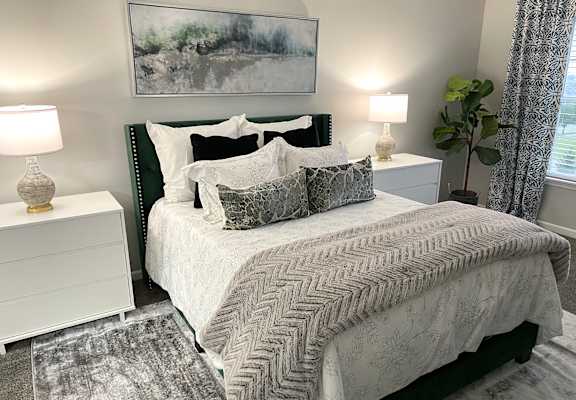 a gray and white bedroom with a bed and pillows
