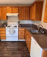 A kitchen with wooden cabinets and a white fridge.