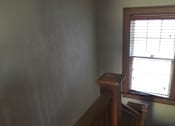 Thumbnail 6 of 6 - A room with a window and a wooden staircase.