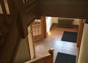 Thumbnail 5 of 6 - A wooden staircase leads up to a second floor.