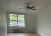 Thumbnail 3 of 28 - A room with wooden flooring and a ceiling fan.