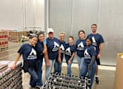 Thumbnail 2 of 5 - A group of people in blue shirts with the word "Residential" on them are standing in a warehouse.