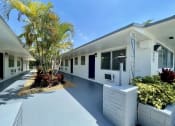Thumbnail 2 of 5 - a long white building with a palm tree in front of it at Lakeside @ Biscayne Gardens,North Miami, FL,33181