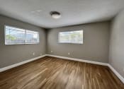 Thumbnail 10 of 12 - an empty living room with wood flooring and two windows  at Palm Gardens @ Biscayne Gardens, Florida