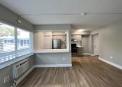 Thumbnail 9 of 12 - an empty living room and kitchen with a large window  at Palm Gardens @ Biscayne Gardens, North Miami, FL, 33181