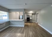 Thumbnail 3 of 12 - an empty living room and kitchen with a large window  at Palm Gardens @ Biscayne Gardens, North Miami, FL