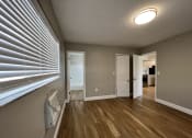 Thumbnail 7 of 12 - an empty living room with a large window and wood flooring  at Palm Gardens @ Biscayne Gardens, North Miami, FL