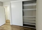Thumbnail 12 of 40 - a bedroom with an empty closet and a hallway with a door open