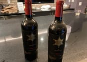 Thumbnail 1 of 7 - two bottles of wine sitting on a counter