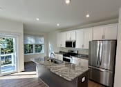 Thumbnail 5 of 18 - A modern kitchen with a stainless steel refrigerator and wooden ceiling.