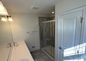 Thumbnail 12 of 18 - A bathroom with a skylight and a white sink.