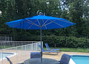 Thumbnail 13 of 14 - A blue umbrella is next to a pool.