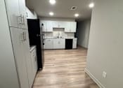 Thumbnail 4 of 9 - A modern kitchen with a white countertop and wooden walls.