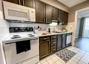 Thumbnail 3 of 28 - A kitchen with white appliances and black cabinets.