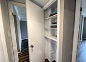 Thumbnail 7 of 28 - an open white closet door with towels on the shelves