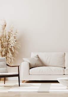 A white couch with a bowl on the floor in front of it. at Tides on East Cactus Apartments, Phoenix