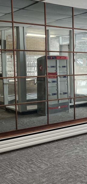 an empty room with glass walls and a vending machine