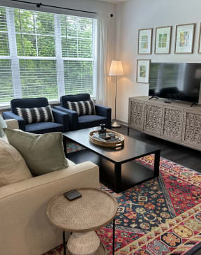 a living room with white walls and a large window