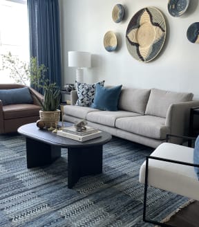 a living room with a gray couch and blue pillows