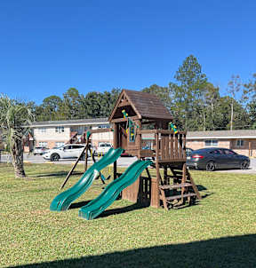 A playground with a slide and a wooden structure.