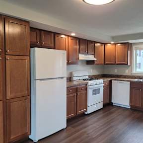 A kitchen with wooden cabinets and white appliances.