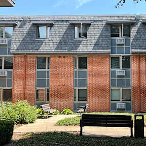 A brick building with a bench in front of it.