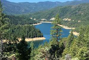 A beautiful landscape with a lake surrounded by trees and mountains.