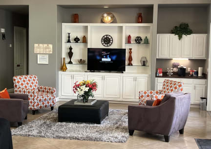 a living room with couches and chairs and a tv