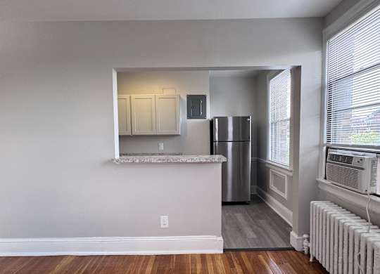 A room with a white wall and a wooden floor.