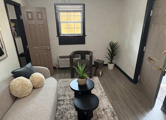 A living room with a grey couch and a wall with a black and white pattern at Waverly Manor Townhomes, Georgia