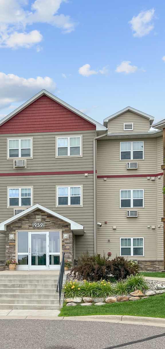 A large apartment complex with a front entrance and landscaping.