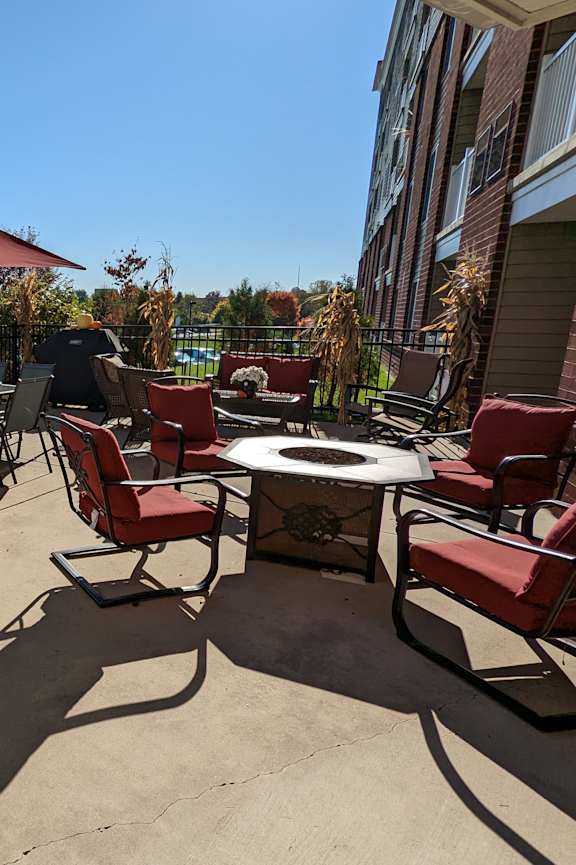 A patio with a table, chairs, and an umbrella.
