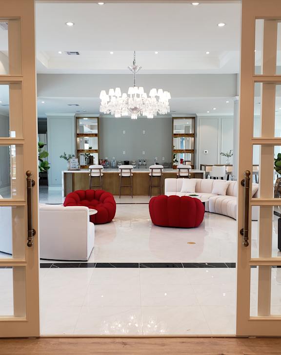 A modern living room with a red sofa and a chandelier.