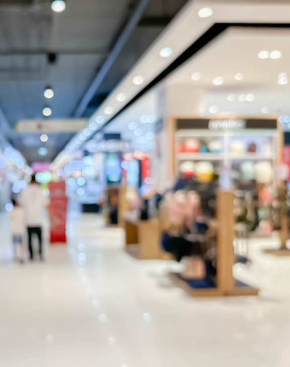 A blurry image of a shopping mall with people walking around.