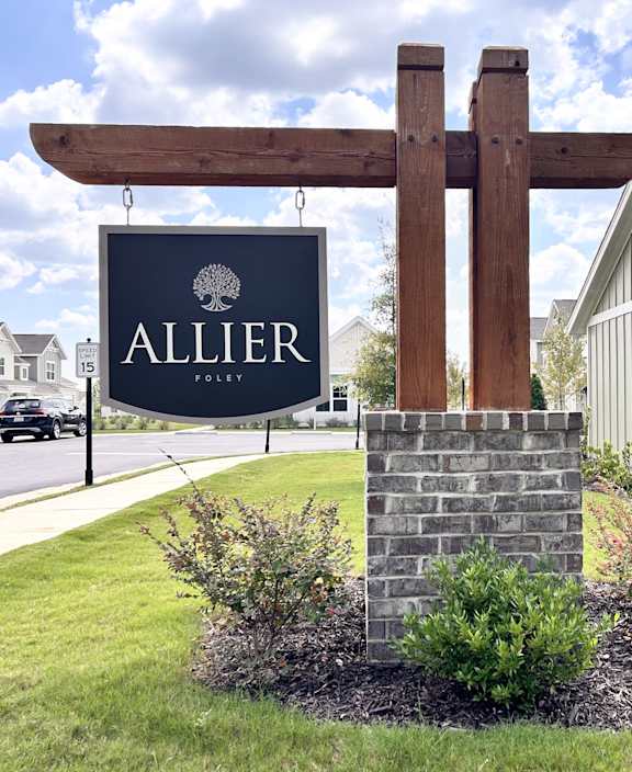 A wooden signpost with a sign at Allier Foley in Foley, AL