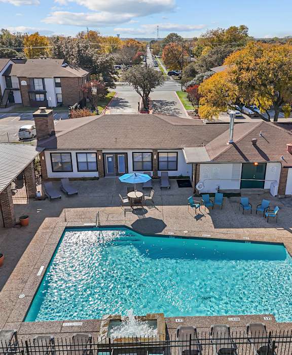 A swimming pool in a backyard surrounded by a fence.