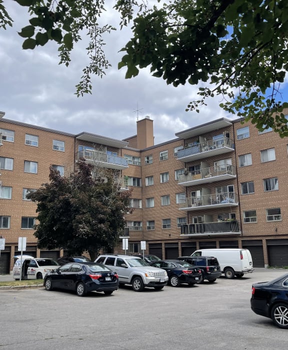 a large brick apartment building with a parking lot in front of it