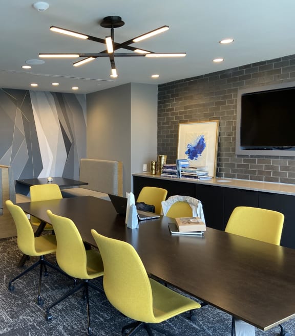 a conference room with a wooden table and yellow chairs in Tribeca NOMA apartments
