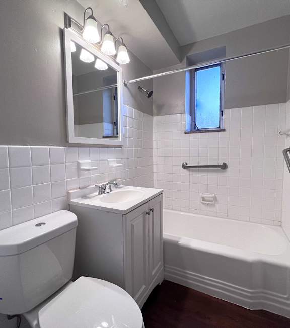 A white bathroom with a toilet, sink, and bathtub.