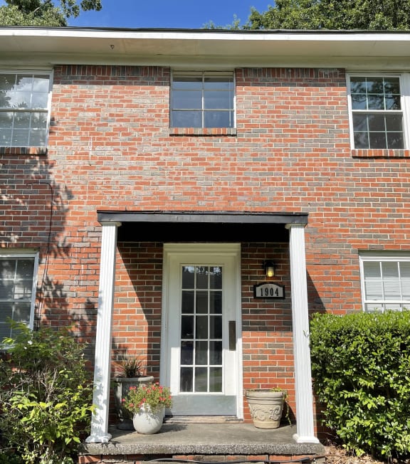 the front of a brick house with a white door