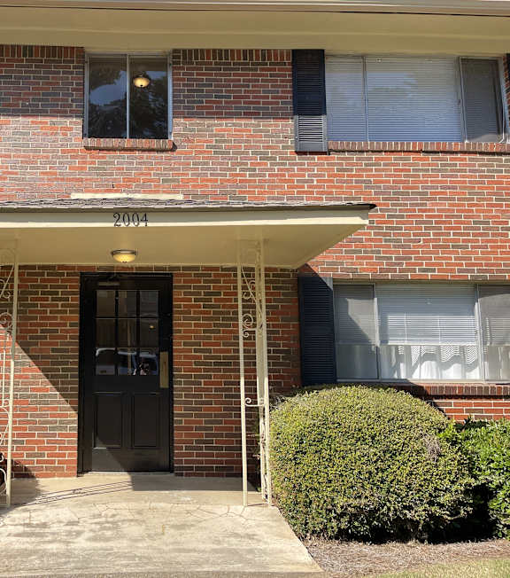the front of a brick building with a black door