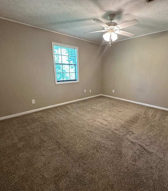 a bedroom with carpet and a ceiling fan